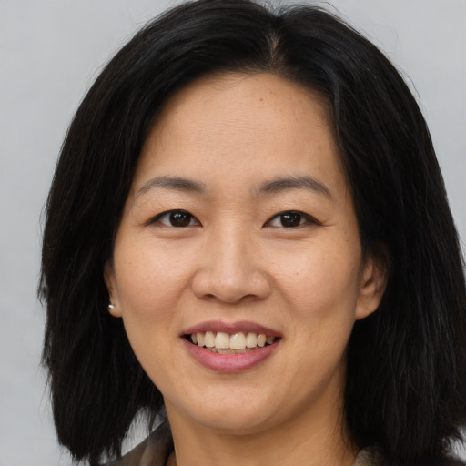 Joyful asian young-adult female with long  brown hair and brown eyes