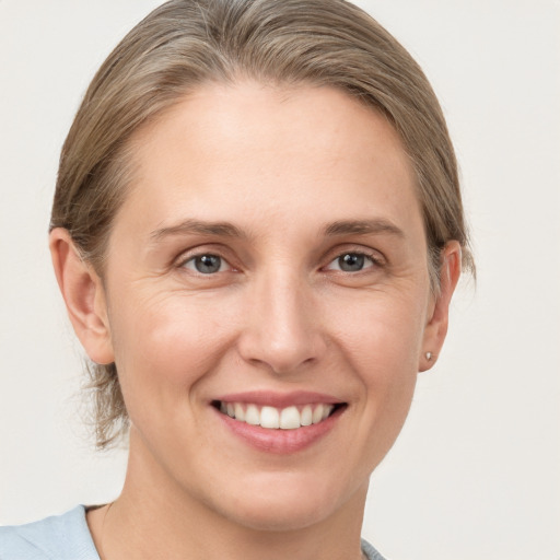 Joyful white young-adult female with medium  brown hair and grey eyes