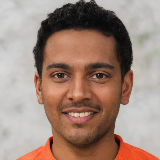Joyful latino young-adult male with short  black hair and brown eyes