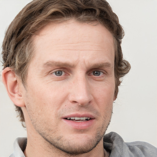 Joyful white adult male with short  brown hair and grey eyes