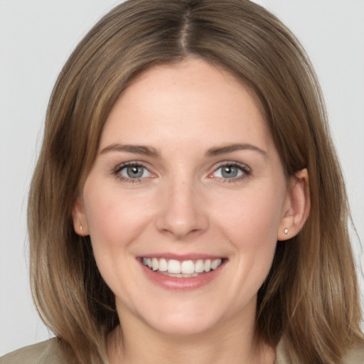 Joyful white young-adult female with medium  brown hair and grey eyes