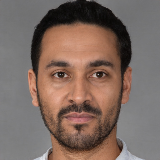 Joyful latino young-adult male with short  black hair and brown eyes