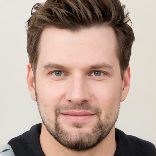 Joyful white young-adult male with short  brown hair and grey eyes