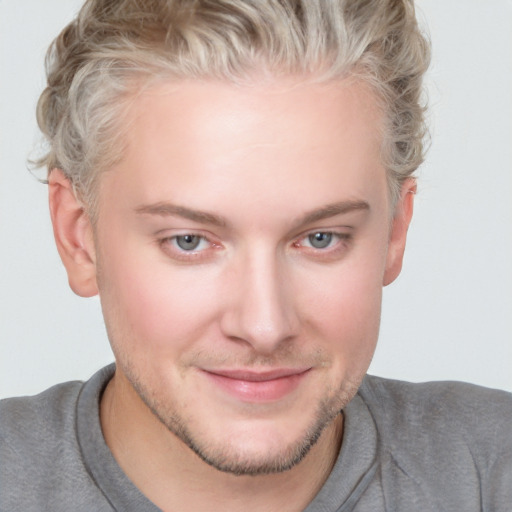 Joyful white young-adult male with short  brown hair and blue eyes