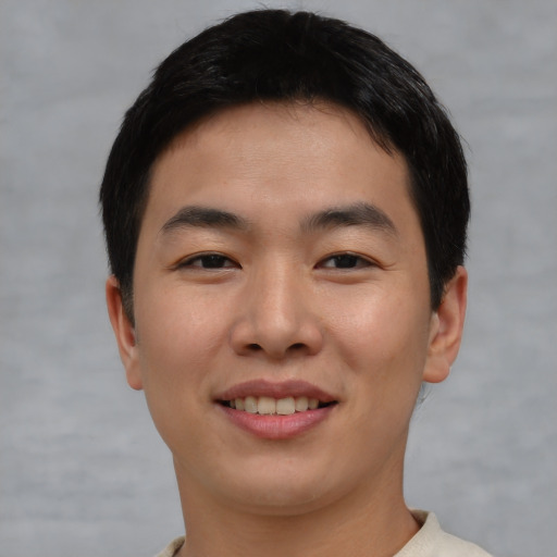 Joyful asian young-adult male with short  brown hair and brown eyes