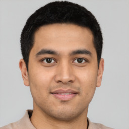 Joyful latino young-adult male with short  brown hair and brown eyes