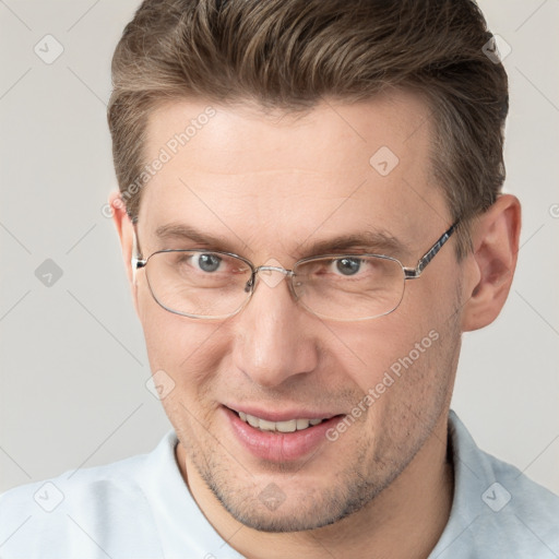 Joyful white adult male with short  brown hair and grey eyes