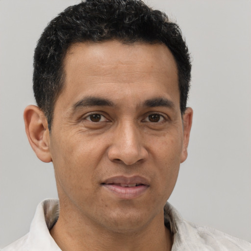 Joyful latino adult male with short  brown hair and brown eyes