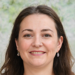 Joyful white adult female with long  brown hair and brown eyes