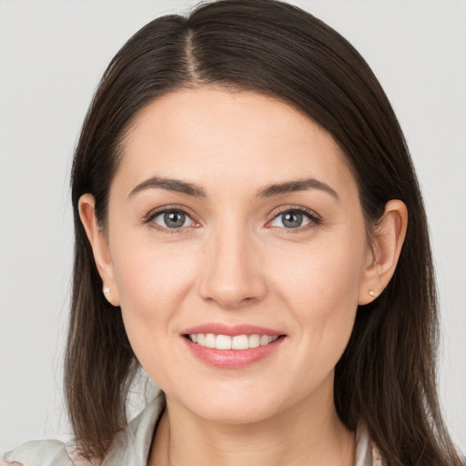 Joyful white young-adult female with long  brown hair and brown eyes