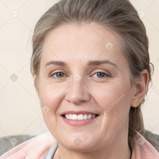 Joyful white young-adult female with medium  brown hair and grey eyes