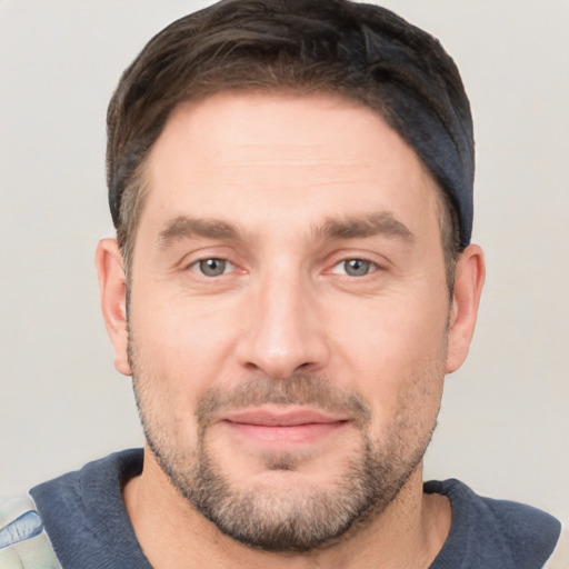 Joyful white adult male with short  brown hair and grey eyes