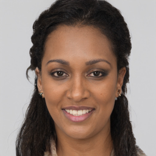Joyful black young-adult female with long  brown hair and brown eyes