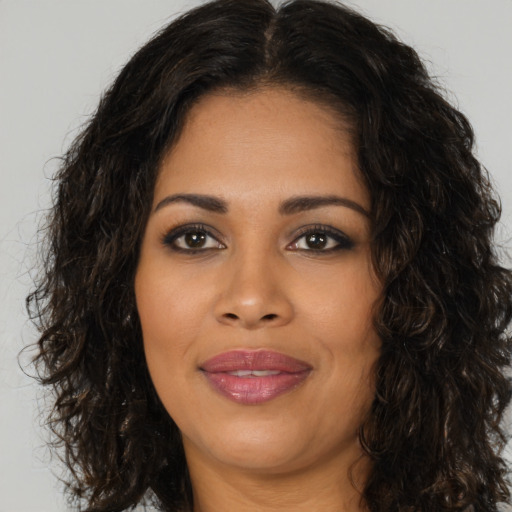 Joyful black young-adult female with long  brown hair and brown eyes