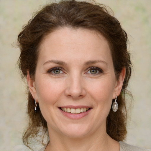 Joyful white adult female with medium  brown hair and green eyes