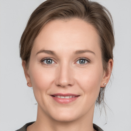 Joyful white young-adult female with medium  brown hair and grey eyes