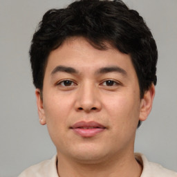 Joyful asian young-adult male with short  brown hair and brown eyes