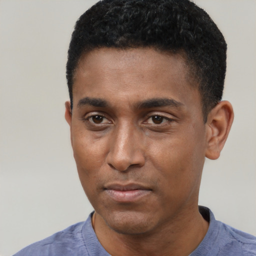 Joyful black young-adult male with short  black hair and brown eyes