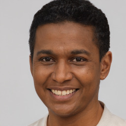 Joyful latino young-adult male with short  brown hair and brown eyes