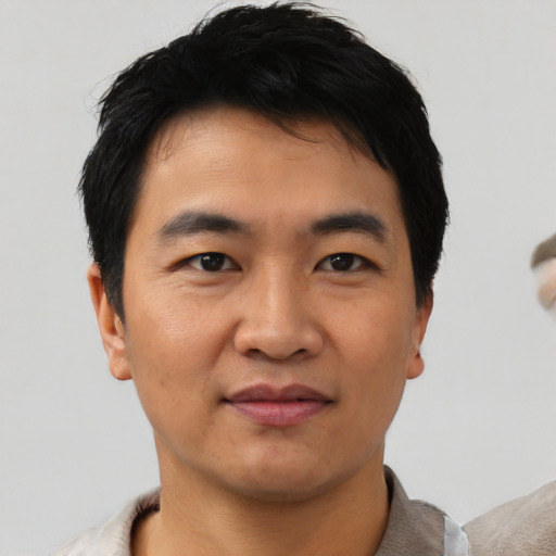 Joyful asian young-adult male with short  black hair and brown eyes