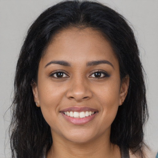 Joyful latino young-adult female with long  brown hair and brown eyes