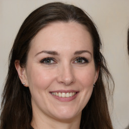 Joyful white young-adult female with long  brown hair and grey eyes