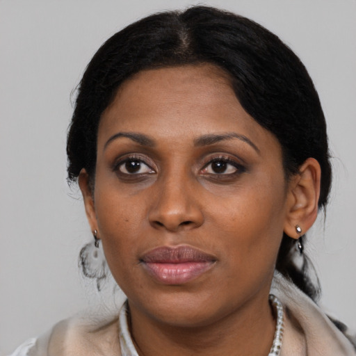 Joyful black young-adult female with short  black hair and brown eyes