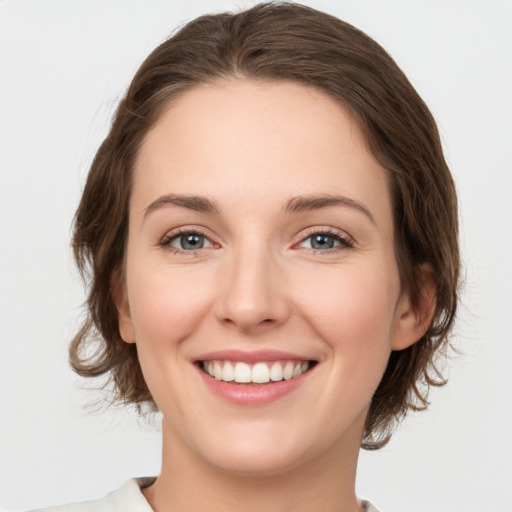 Joyful white young-adult female with medium  brown hair and green eyes