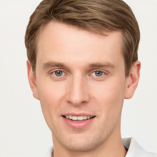 Joyful white young-adult male with short  brown hair and grey eyes