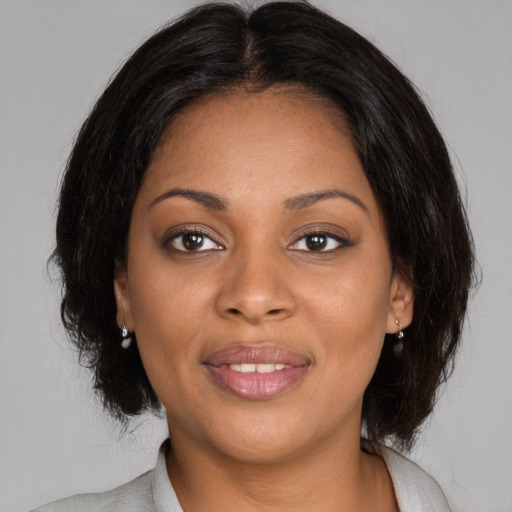 Joyful black young-adult female with medium  brown hair and brown eyes