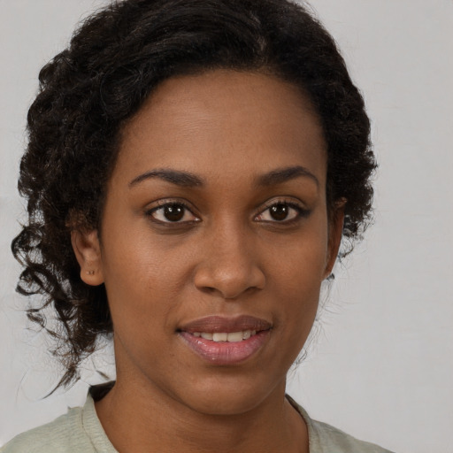 Joyful black young-adult female with medium  brown hair and brown eyes