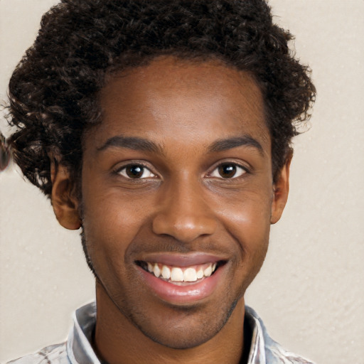 Joyful black young-adult male with short  brown hair and brown eyes