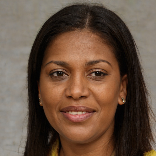 Joyful black adult female with long  brown hair and brown eyes