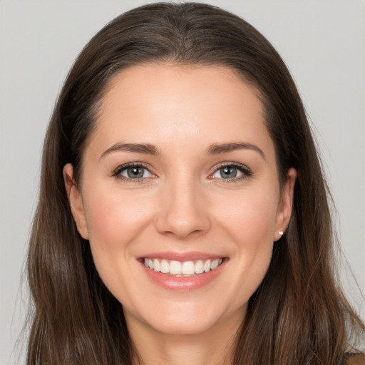 Joyful white young-adult female with long  brown hair and brown eyes