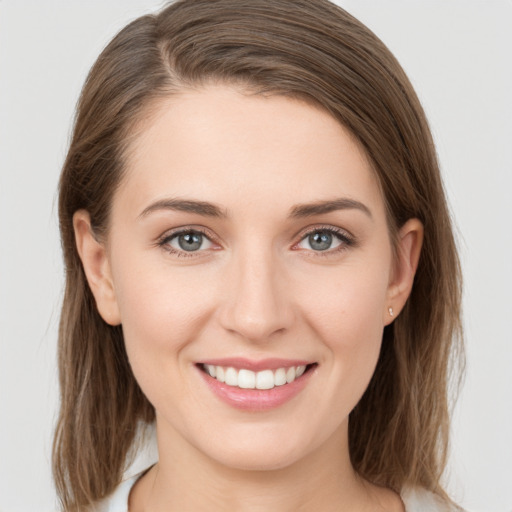 Joyful white young-adult female with medium  brown hair and grey eyes