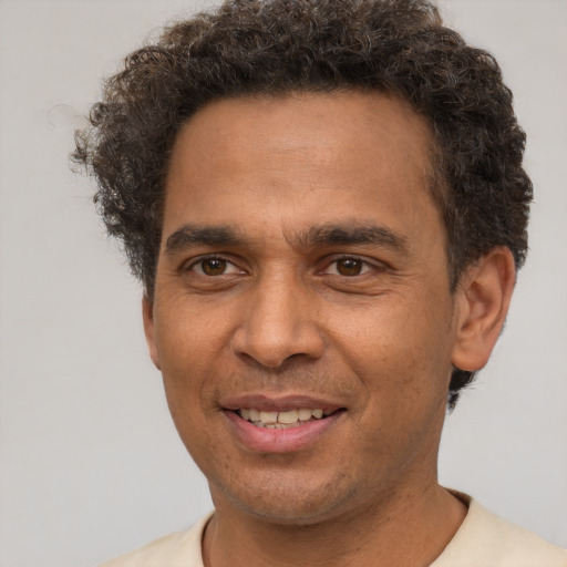 Joyful latino young-adult male with short  brown hair and brown eyes