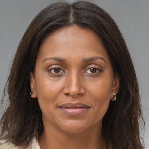 Joyful black adult female with long  brown hair and brown eyes