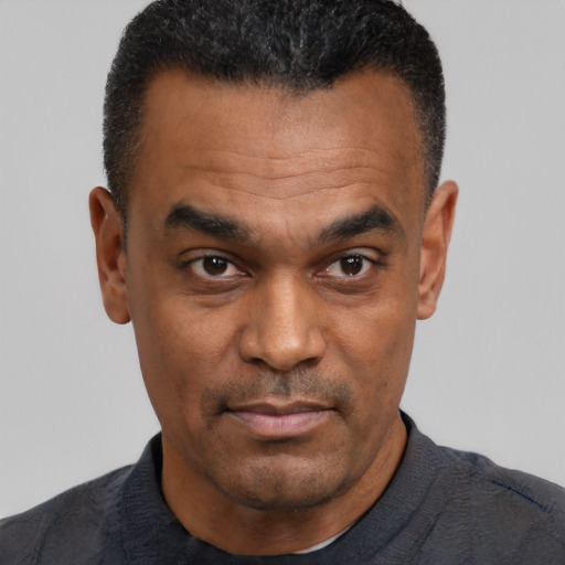Joyful black adult male with short  black hair and brown eyes