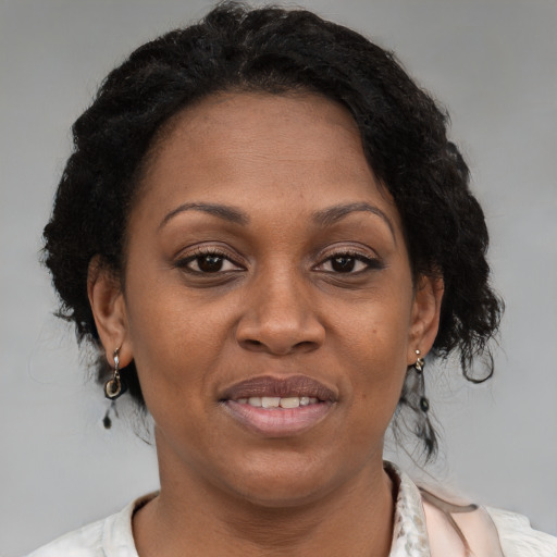 Joyful black adult female with medium  brown hair and brown eyes