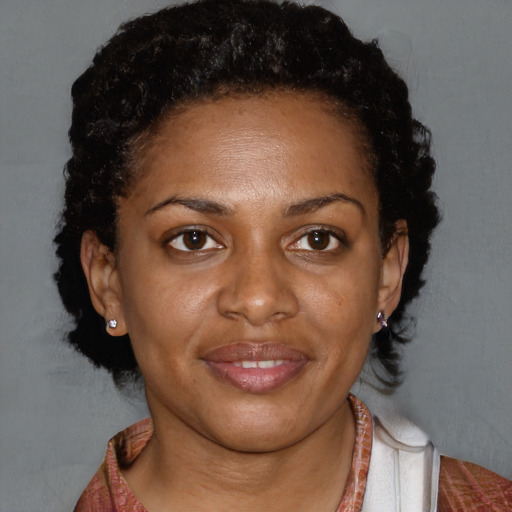 Joyful black adult female with medium  brown hair and brown eyes