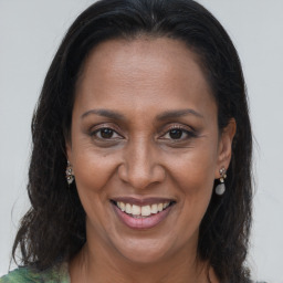 Joyful black adult female with long  brown hair and brown eyes