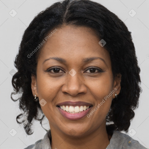 Joyful black adult female with medium  brown hair and brown eyes