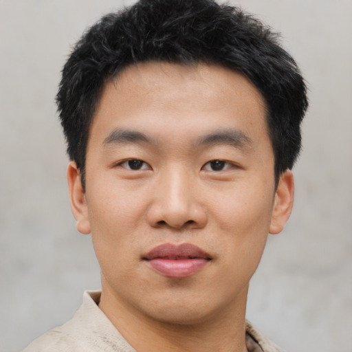 Joyful asian young-adult male with short  black hair and brown eyes