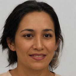 Joyful latino young-adult female with medium  brown hair and brown eyes