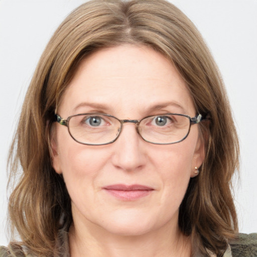 Joyful white adult female with medium  brown hair and blue eyes