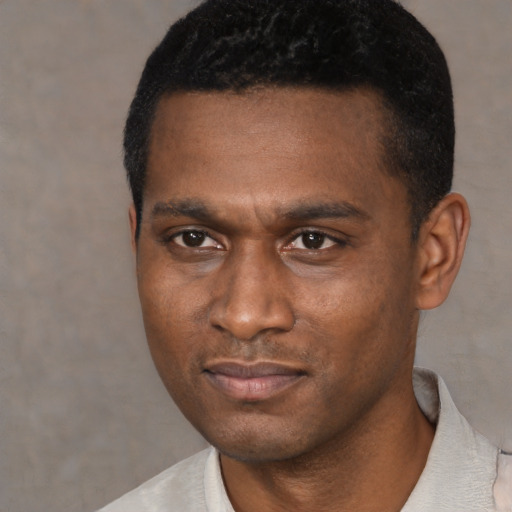 Joyful black young-adult male with short  black hair and brown eyes