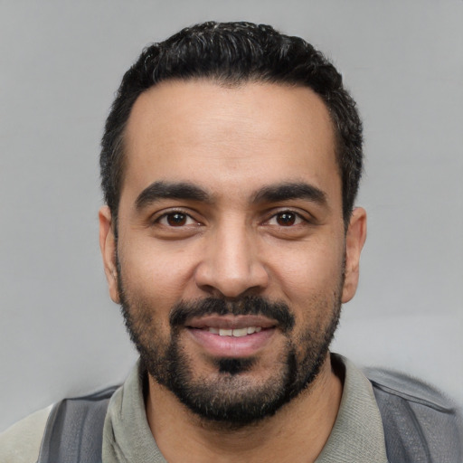 Joyful latino young-adult male with short  black hair and brown eyes