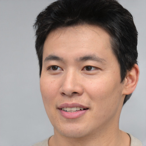 Joyful asian young-adult male with short  brown hair and brown eyes