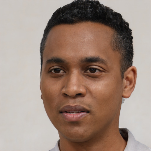 Joyful black young-adult male with short  black hair and brown eyes