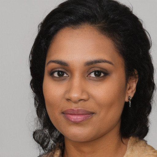 Joyful black young-adult female with long  brown hair and brown eyes